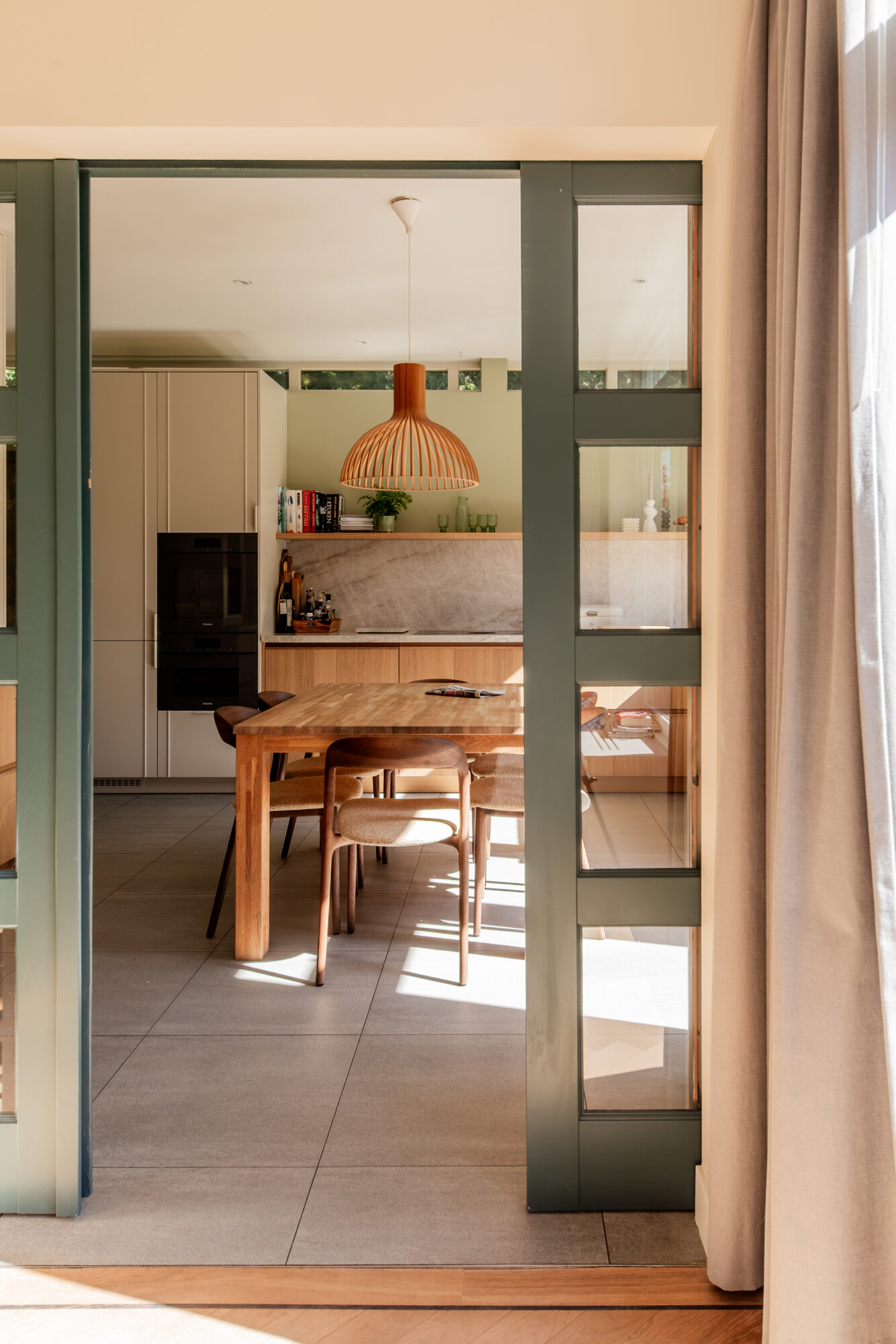 Doorkijk door de ensuite deuren naar de keuken in een jaren 30 woning