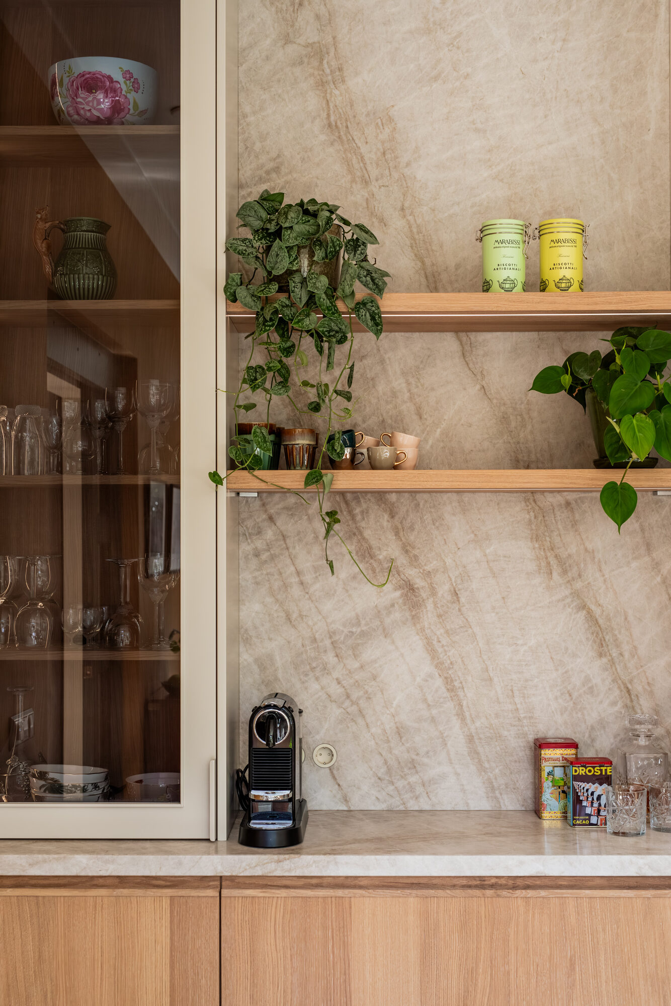 Eiken planken bij servieskast tegen een backsplash van Taj Mahal kwartsiet met planten