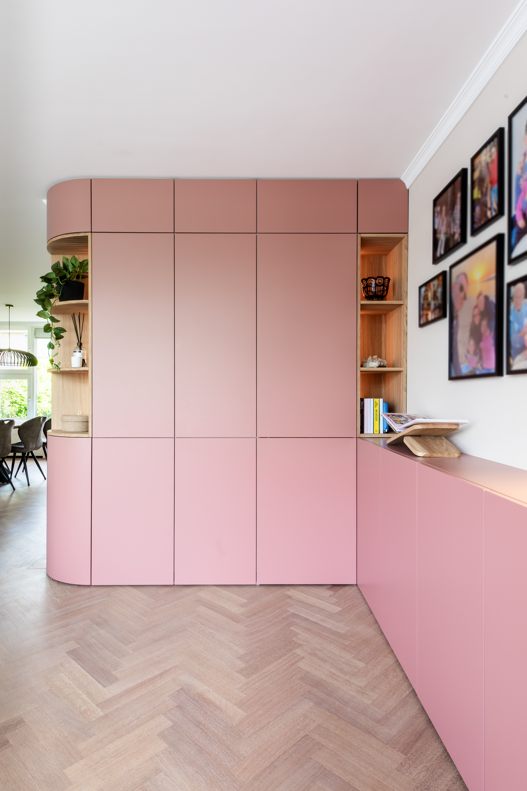 Maatwerkkast in terra-roze met verlichte eiken nissen en doorkijk naar de eetkamer, interieurontwerp woning Bennebroek door Authentic Interiors