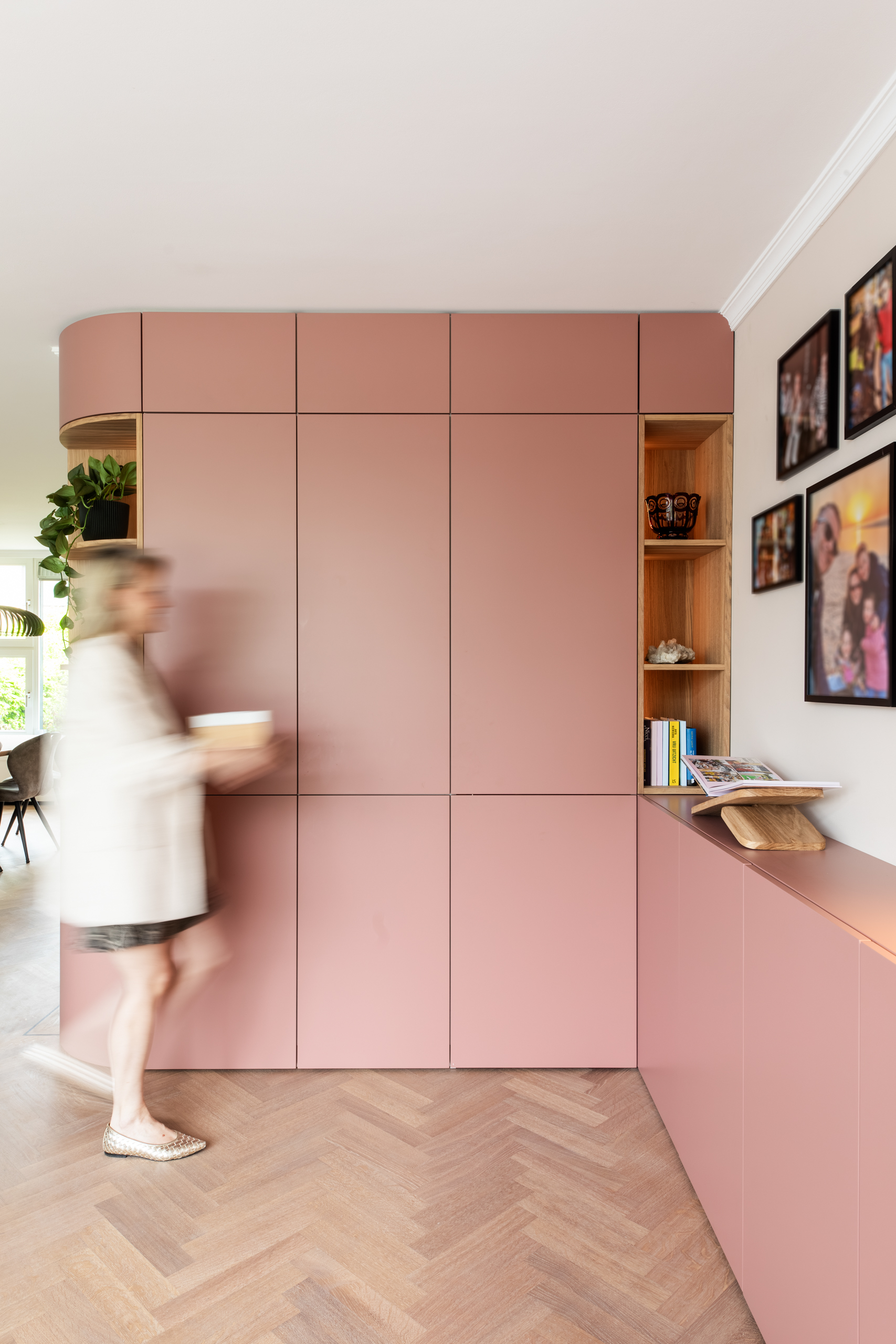 Interieurontwerper Lisette van de Wouw loopt langs de terra-roze maatwerkkast, woning Bennebroek, Authentic Interiors