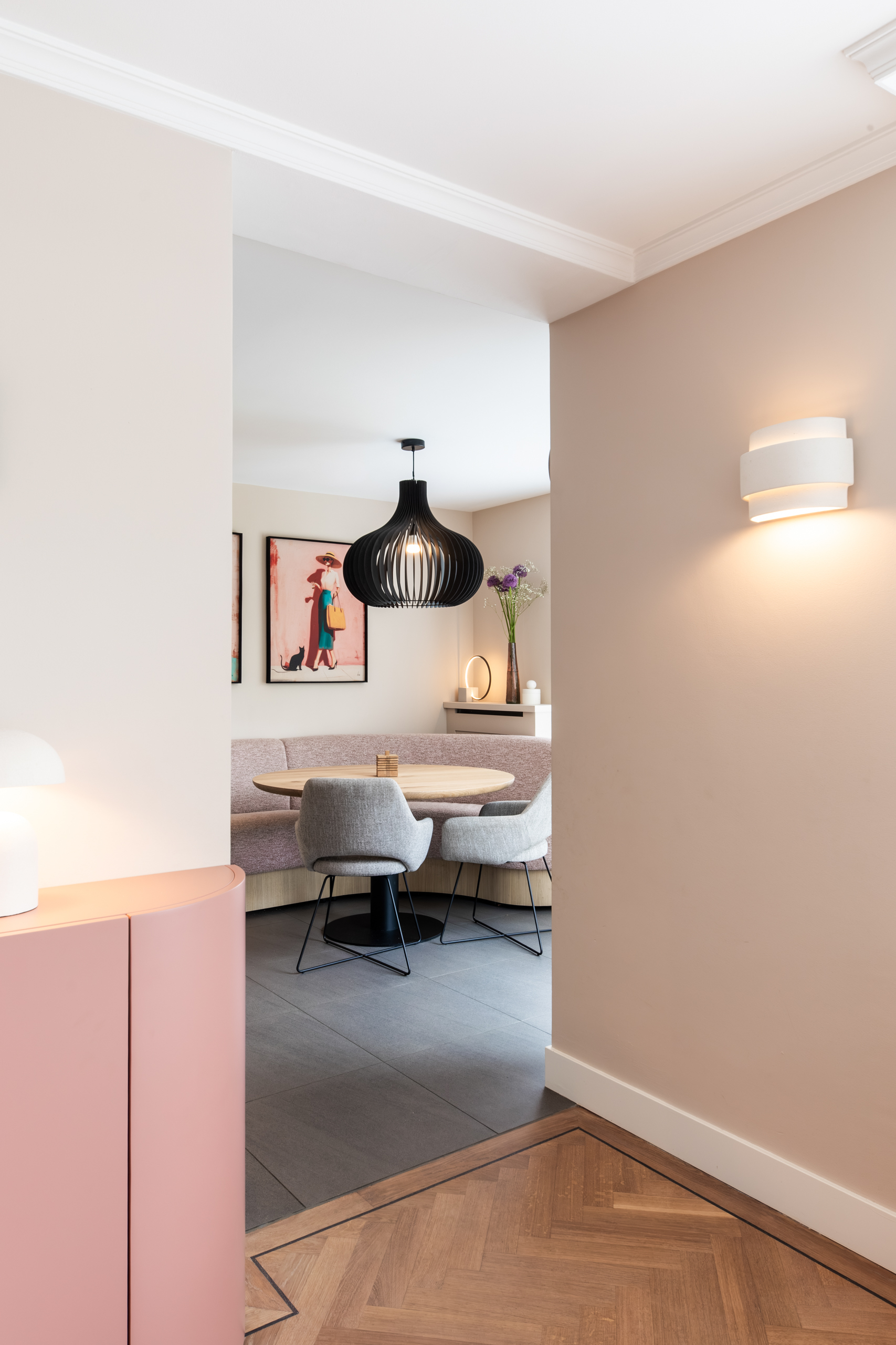 Doorkijk vanaf de maatwerkkast naar de eethoek met ronde tafel en bouclé zitbank, interieurontwerp woning Bennebroek door Authentic Interiors