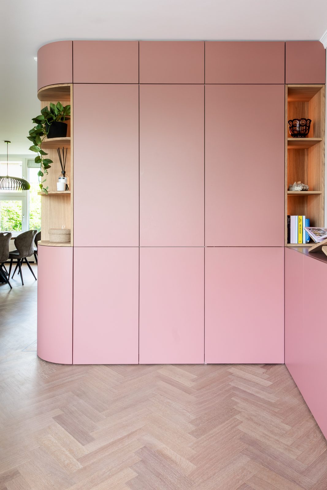 Roze maatwerkwand met afgeronde hoeken en eiken nissen op een visgraatvloer, woning in Bennebroek, ontwerp Authentic Interiors